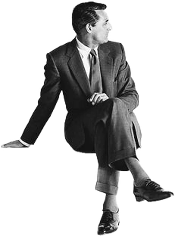 A man in a tailored suit, seated and looking off to one side.