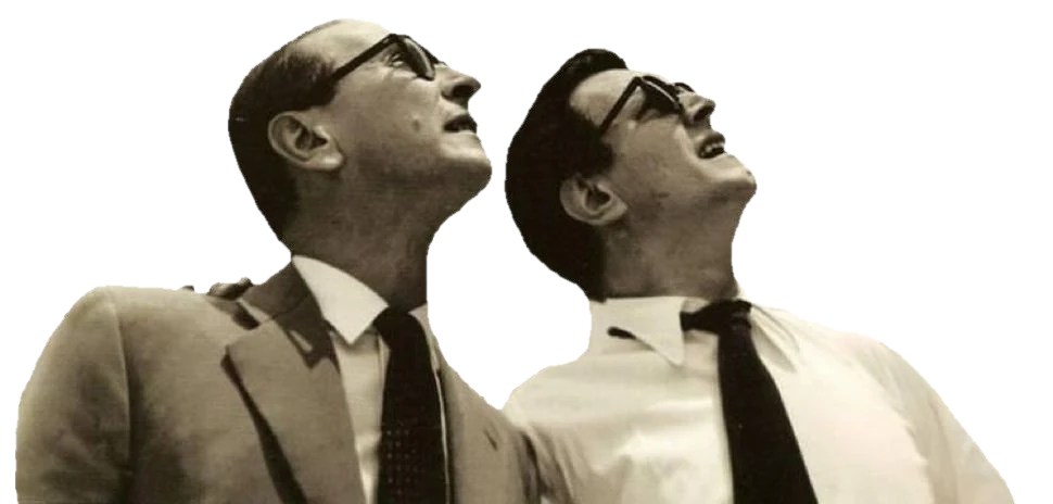 Two men in horn-rimmed glasses, photographed from below, looking up.